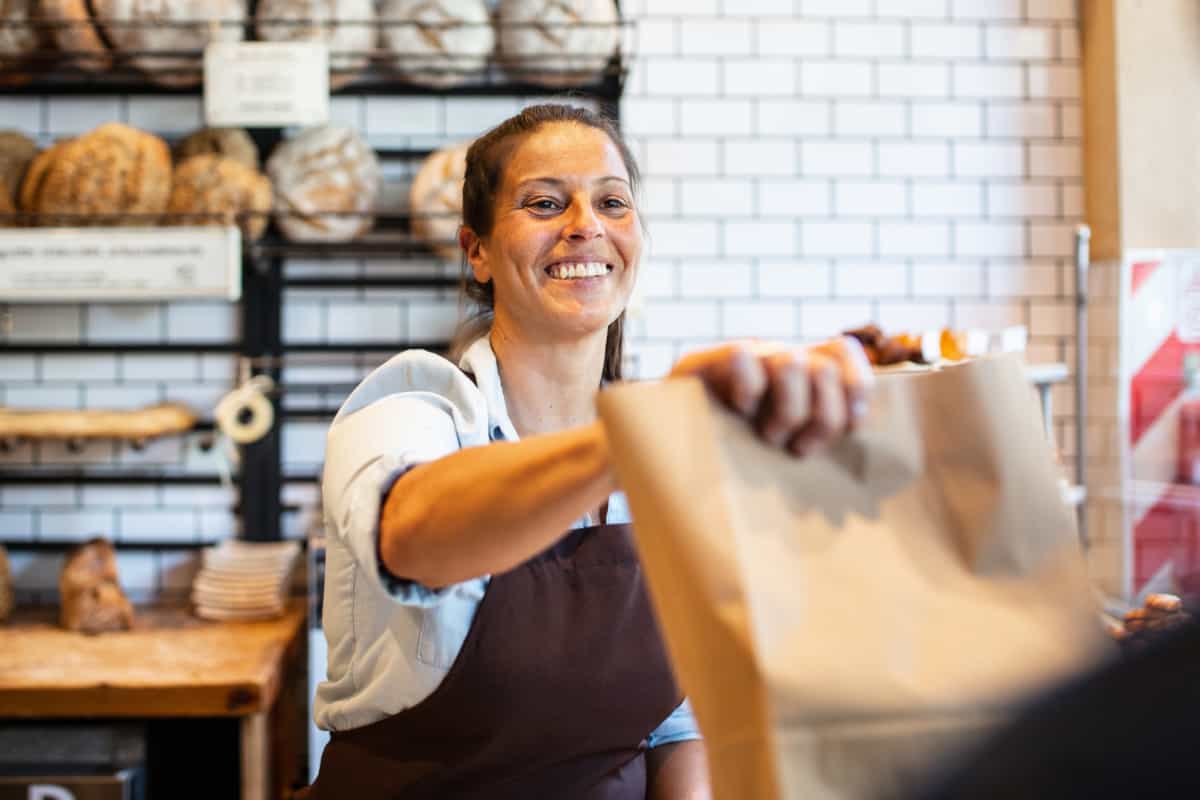 Tenant handing order to customer in bakery