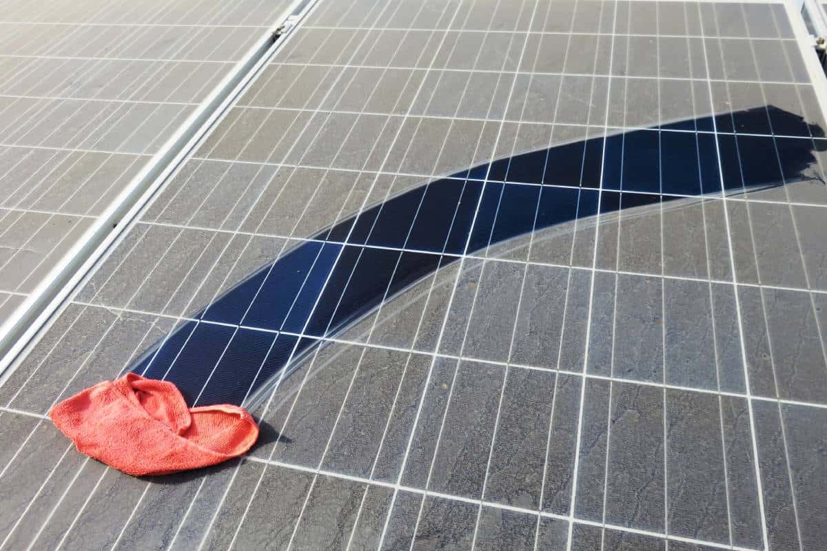 Dirty solar panel swiped with dusty red rag