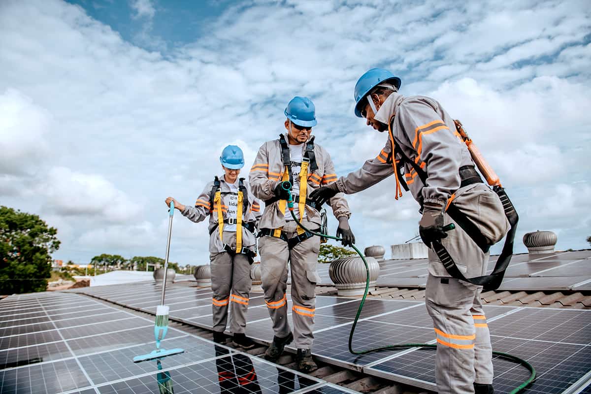 Team working to clean solar on commercial roof