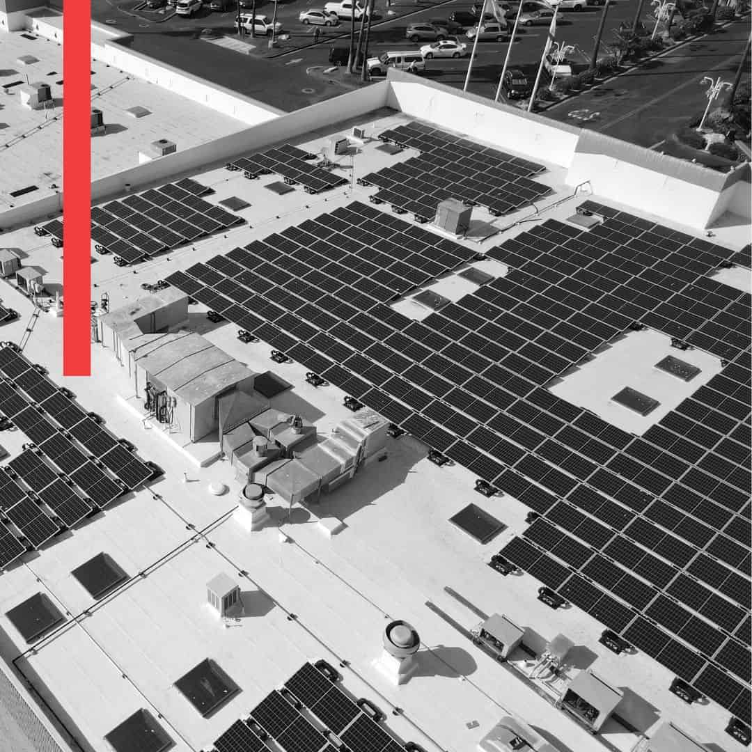 black and white image of solar panels on a flat commercial rooftop
